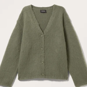 Olivgrön kofta från Monki - Olivgrön kofta från Monki med v-ringning och knappar framtill. Fluffiga textur. Finns inte kvar i storlek 