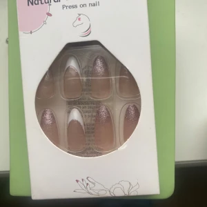 Press-on naglar med glitter och fransk design - Snygga press-on naglar med en elegant fransk design och glittriga detaljer. Perfekt för en snabb och stilren manikyr. Innehåller flera naglar i olika storlekar för bästa passform. Får med klister till naglarna.