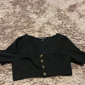 Svart bolerotopp från CBR - Säljer en stilren svart bolerotopp från CBR med trekvartsärm och knappar framtill. 