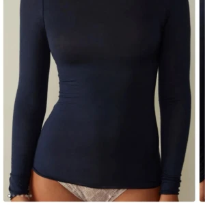 mörkblå långärmad topp - Snygg och enkel svart långärmad topp som passar perfekt till vardags. Den har en tight passform och är tillverkad i ett mjukt material för extra komfort.