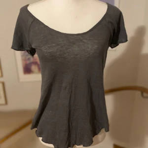 Grå topp från Zara - Säljer en stilren grå topp från Zara med korta ärmar och rund halsringning. Lite genomskinlig men snyggt. Perfekt för en avslappnad look. Toppen har en mjuk och bekväm passform.