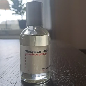 Sherman 78.0 Extrait de Parfum - Säljer en elegant flaska Sherman 78.0 Extrait de Parfum. Flaskan är genomskinlig med en stilren etikett i vitt och rött. Parfymen har en metallisk grå kork och en praktisk sprayfunktion. Inspirerad av killians smoking hot. En unik doft som påminner om lakrits och konjak. Använt ca 5 spray. Är öppen för byten. 
