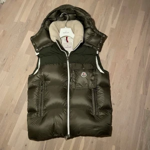 Moncler väst  - Skick 9.5/10. Slutsåld överallt! Storlek 2 passar M bäst. Nypeis 12 000kr. Alla tags och extra knappar och galje medföljer. 
