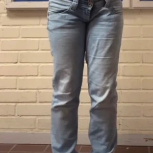 Ljusblå jeansbyxor - Snygga ljusblå jeansbyxor med en klassisk femficksdesign och knappgylf. Perfekta för en avslappnad stil. De har en normal passform och är tillverkade i ett bekvämt denimtyg. GYLFEN ÄR TRASIG. dock syns inte de alls eftersom den är så kort 