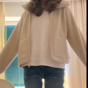 Teddyjacka H&M - Mysig beige teddyjacka med dragkedja framtill och stora fickor. Perfekt för kyliga dagar när du vill hålla dig varm och bekväm. Jackan har en hög krage och långa ärmar. Oversized