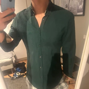 Burberry Brit - Snygg grön långärmad skjorta med knappar framtill. Perfekt för en stilren look. Skjortan har en klassisk krage och är tillverkad i ett bekvämt material.