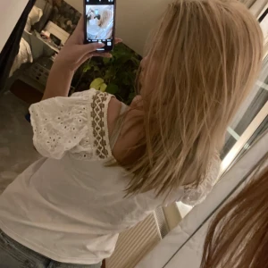 Vit blus med spetsdetaljer - Säljer en söt vit blus med spetsdetaljer på ärmarna. Blusen har korta ärmar och en rund halsringning. Perfekt för en somrig look! 🌼bra skick❤️pris kan alltid diskuteras!!