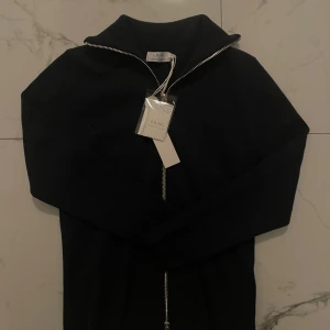 Zip up från Ljung - Säljer en stilren svart ribbad kofta från Ljung med dragkedja. Den är perfekt för det kommande vädret. Helt ny aldrig använt köpt för 1500kr men säljer lite billigare då den inte passar 