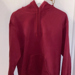 Röd hoodie från H&M - Säljer en röd hoodie från H&M i relaxed fit. Den har en klassisk design med huva och en stor magficka. Perfekt för en avslappnad stil. 