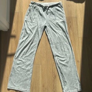 Grå mjukisbyxor från Juicy Couture - Säljer ett par superbekväma grå mjukisbyxor från Juicy Couture. De har en loose passform med breda ben och är gjorda i mjukt material. Byxorna har snörning i midjan. Vid frågor ställ via PM. 10/10 Skick. (Nypris:-1099)