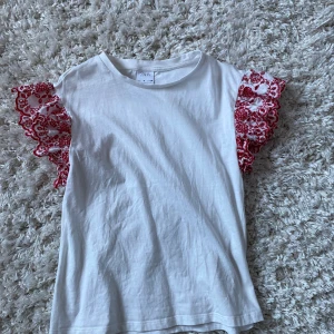 Vitt T-shirt  - Storlek: 134CM Fin T-shirt med röda vålanger från Zara 