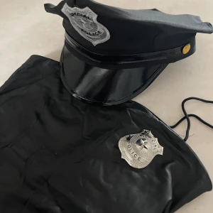 Polis dräkt  - Halloween dräkt som köptes förra året, hatten var sne när den köptes, klänningen är i storlek s och det ingår en polisbricka 