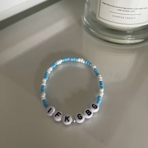 Armband med bokstavspärlor - Säljer ett coolt armband med bokstavspärlor som stavar 'IFK GBG'. Armbandet har blå och vita pärlor som ger en fräsch look. Perfekt för att visa ditt stöd för laget eller bara som en snygg accessoar!
