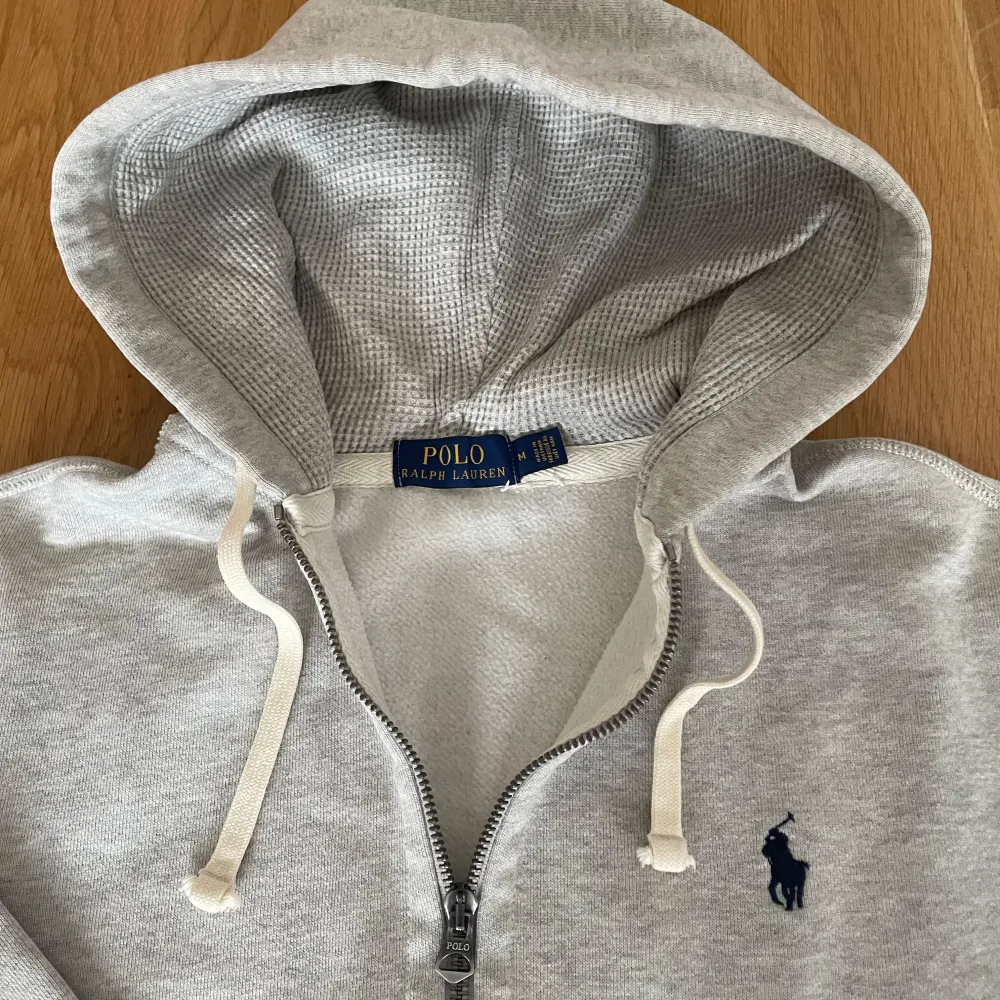 Storlek M i melerad grå. Hoodien är i väldigt fint skick utan noppor eller andra defekter. Hör av er om frågor!. Hoodies.