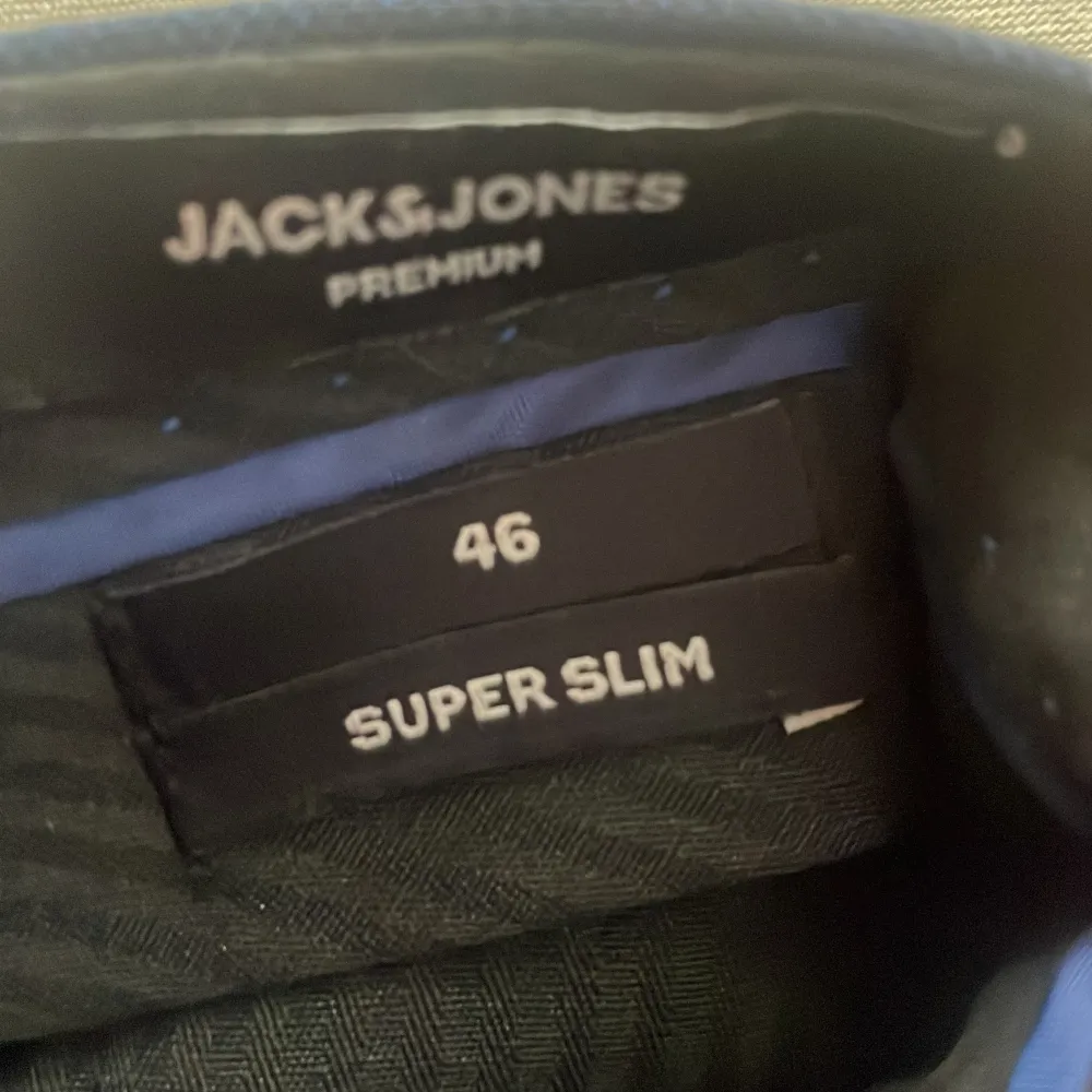 Säljer ett par eleganta mörkblå kostymbyxor från Jack & Jones i storlek 46. De har en super slim passform som ger en stilren och modern look. Byxorna är perfekta för formella tillfällen eller när du vill klä upp dig lite extra. . Jeans & Byxor.