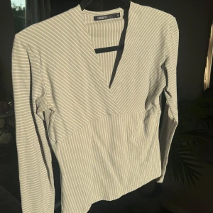 Ljusblå topp - Fin långärmad ljusblå och vit randig topp. Stretchig och skön på.