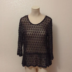 Svart spetsblus med trekvartsärm - Säljer en elegant svart spetsblus med ett unikt mönster. Blusen har trekvartsärmar och en rund halsringning. Perfekt för en festlig kväll eller en stilfull dag på stan. Den är genomskinlig och litw stretchig.