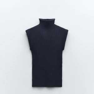 Svart ribbad ärmlös topp - Säljer en stilren mörkblå ribbad topp med hög krage. Perfekt för lager-på-lager eller att bära som den är. Toppen är ärmlös och har en tight passform som framhäver figuren. Passar både till vardags och fest!