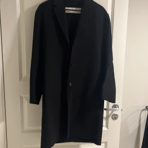 Svart ullkappa Arket st.34 - Jättefin kappa i ull från Arket. Lite oversize modell så passar både XS och S. Skick 9/10