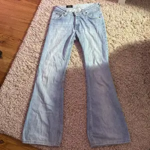 Bootcut jeans från lee. Köpt begagnade, defekterna är att lappen där bak är lite uppe och de har ett litet hål där bak, men det syns knappt (se på bilder). Innerbenslängden är 79cm och midjemåttet tvärs över 35cm.