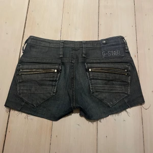 Jeans short med snygga detaljer  - As balla jeans shorts m mycke detaljer! Egentligen ett par skinny jeans men jag har klippt av de, tyvärr är de för tajta för mig där av att jag säljer! Det finns ingen storlek men jag skulle säga XS Midljemått: 35 cm! 