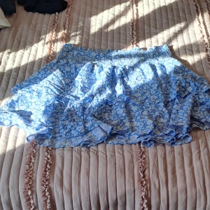 En kjol - En plå kjol med vita små blommor på aldrig andvänd