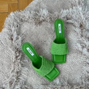 Gröna klackskor från NAKD - Snygga gröna klackskor från NAKD med en fyrkantig tå och flätad rem. Perfekta för sommarens alla fester! De har en stilren design med en bekväm passform.