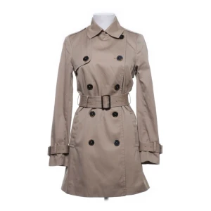 Trench coat - Trenchcoat från H&M i utmärkt skick.  Slutar mitt på låren och har en normal passform. 
