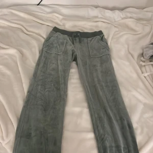 Mjukisbyxor från Juicy Couture i färgen Chinois Green - Säljer ett par gröna mjukisbyxor från Juicy Couture i storlek S. Tyvärr så har en av metallklämmorna ramlat av. 