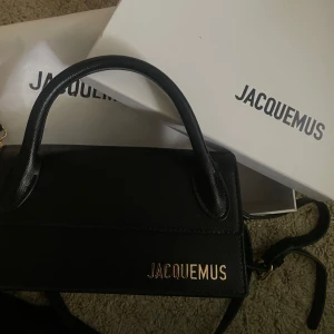 Svart handväska från Jacquemus - Säljer en superfin svart handväska från Jacquemus. Den är i skinn och har en stilren design med ett handtag och en avtagbar axelrem. Perfekt för både vardag  och finare tillfällen💞💞💓 Köpt på en secondhandbutik i Göteborg så har inte något äkthetsbevi