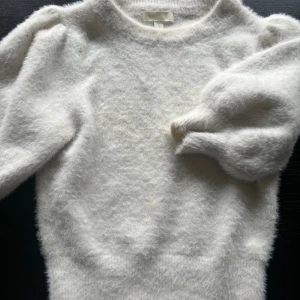 Vit fluffig tröja från H&M - Säljer en supermjuk och fluffig vit tröja från H&M. Den är perfekt för kyliga dagar med sina trekvartsärmar och en tight passform som ger en mysig känsla. Tröjan är i nyskick och passar perfekt till både vardag och fest. 💞 (kan säljas billigare💖)