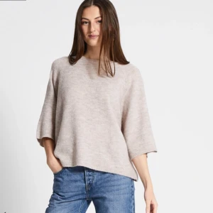 Stickad T-shirt  - En beige stickad T-shirt som är varm och tjock, bra till både höst och vinter. Den är varsamt använd.