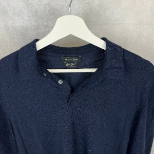 Mörkblå tröja från Massimo Dutti - Snygg mörkblå tröja från Massimo Dutti med krage och knappar. Tröjan har långa ärmar och en ribbad nederkant som ger en stilren look. Perfekt för en avslappnad men ändå uppklädd stil.