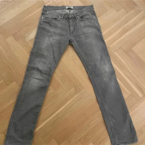 Grå jeans från Acne - Snygga grå jeans från Acne med en klassisk femficksdesign. De har en rak passform och är tillverkade i ett mjukt denimtyg. Perfekta för en stilren look.