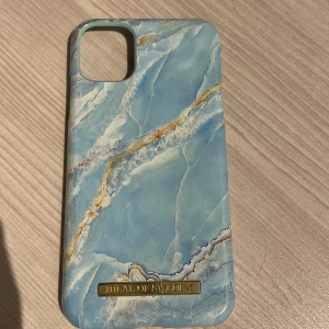 Blått mobilskal från iDeal of Sweden - Snyggt mobilskal från iDeal of Sweden med ett marmorerat mönster i blått och inslag av guld. Skalet har en stilren design och är perfekt för att ge din mobil en unik look. Passar utmärkt för dig som vill ha både stil och skydd. Det är väldigt frasch då jag knappt använt det😇😍Frågor går jätte bra att ställa och pris kan diskuteras!!❤️‍🔥❤️‍🔥🔥🔥