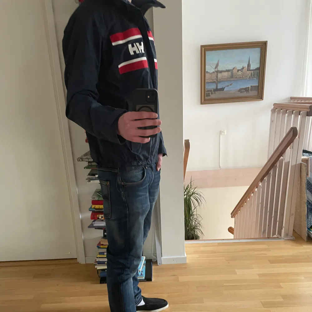 As fet helly Hansen seglarjacka i jätte bra skick, as skön till svala sommarkvällar och våren!! Jag är 187 och väger 73 och den sitter bra. Justerbar midja, vid bilden är den väldigt tajt i midjan. Hör av er vid fler frågor!. Takit.