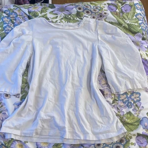 Vit tröja från Zara - Säljer en vit topp från Zara med puffiga armar och rund hals. Toppen har en enkel och stilren design, perfekt för olika tillfällen. Materialet är mjukt och bekvämt.