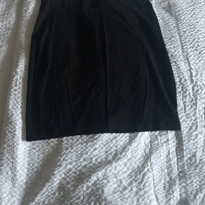 Svart kjol - Snygg svart kjol i enkel design. Perfekt för en stilren look. Kjolen har en klassisk passform och är lätt att matcha med olika toppar.