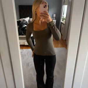 Olivgrön långärmad topp - Så snygg topp med fyrkantig ringning!Svårt att se färgen på bild men skulle beskriva den som lite grågrön. Säljer då den inte kommer till användning💕🤍