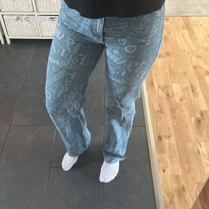 Blå mönstrade jeans - Snygga blå jeans med unikt mönster och raka ben. De har en cool vintage-look med tryck och slitningar. Perfekta för en avslappnad stil.