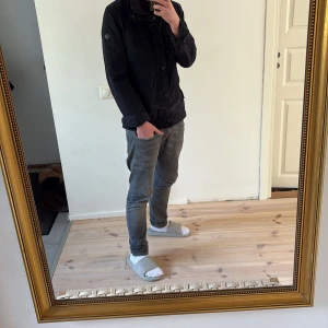 Field jacket från J.Lindeberg - Säljer en stilren mörkblå field jacket från J.Lindeberg i storlek M. Jackan har en dragkedja och knappar framtill samt flera praktiska fickor. Perfekt nu för våren, priset är ej hugget i sten!