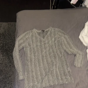 Grå stickad tröja från Street One - Säljer en grå stickad tröja från Street One. Tröjan har en v-ringad design och långa ärmar, perfekt för kyligare dagar. Den är i en stilren grå färg som passar till det mesta. Perfekt för en avslappnad och bekväm stil.