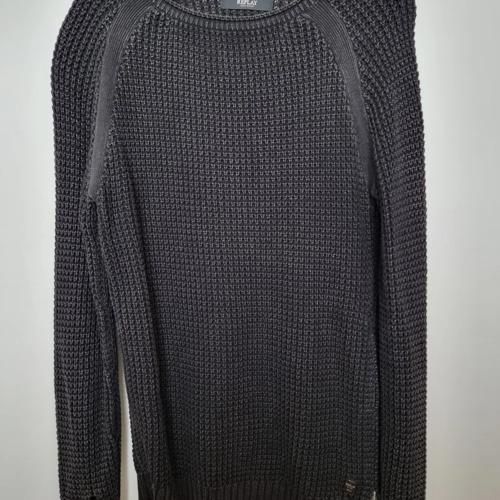 Säljer en snygg mörkgrå stickad tröja från Replay. Tröjan har en klassisk design med långa ärmar och rund halsringning. Perfekt för kyligare dagar och passar till många olika stilar. Ett måste i garderoben för den som gillar stilrena plagg.Använd endast ett fåtal gånger då jag har flera . Neuletakit & Villapaidat.