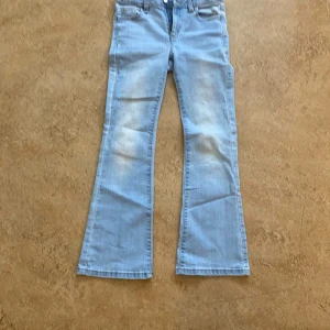 Ljusblå bootcut jeans - Snygga ljusblå bootcut jeans från märket Cubus.De har en klassisk femficksdesign och en bekväm passform. Perfekta för en avslappnad stil med en touch av retro.