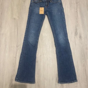 Low waist bootcut jeans från Hollister - Snygga blå bootcut low waist jeans från hollister, köpte från Sellpy men är lite små, storlek 24 / 33, lågmidjade och utsvängda
