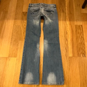 Lågmidjade bootcut Jeans - Suuupersnygga jeans i en bootcut modell med låg midja😇💓 De är använda men i bra skick, några vita små prickar på baksidan av ett ben och ett liiitet hål!💓 Storlek 27! Måtten är: 37cm rakt över midjan 81cm innerben 17,5cm grenmått! Färgen syns bäst på sista bilden💓