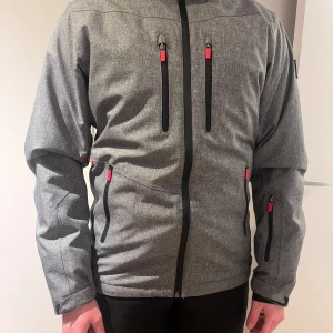 Skidjacka Dr.zipe - Säljer en grå skidjacka från Dr.zipe!✨Svarta dragkedjor och röda detaljer. Jackan har flera fickor, snöskydd, innerfickor och ventilations hål. En stor logga på ryggen som en snygg design. Inga defekter, storlek S och fungerar som ny! Kom gärna med prisförslag och frågor!✌🏼