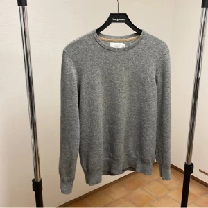 Grå kashmirtröja från Riley - Säljer en stilren grå kashmirtröja från Riley. Tröjan är långärmad och har en klassisk rund halsringning. Perfekt för kyligare dagar med sin mjuka och lyxiga känsla. Passar både till vardags och mer uppklädda tillfällen. Riktigt skön!