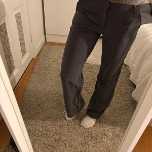  kostymbyxor - Fina mörkgrå kostymbyxor.  Byxorna har en rak stil och är perfekta för en stilren look. De har en dragkedja framtill och är medelhöga för en bekväm passform. Gott skick. Passar både S/M. 