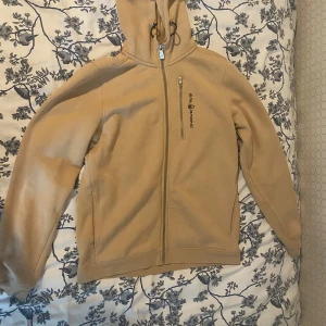 Beige kofta  - Beige kofta från sail raicing. Använd ett par gånger, men är i bra skick. Storlek 176 för barn, men passar vuxna. Skulle kunna passa kvinnor som bär storlek xs-m. Den är perfekt för hösten i vintern, och håller en varm.